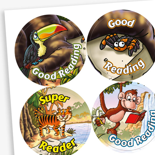 Colourful circular reward stickers, each featuring a jungle animal and a reading-themed message. Top left: a toucan on a tree branch with the words 'Good Reading'. Top right: a smiling spider on a leaf with the partially covered text 'Good Reading'. Bottom left: a cheerful tiger with the phrase 'Super Reader'. Bottom right: a monkey holding a red book near a waterfall, with the text 'Good Reading'.