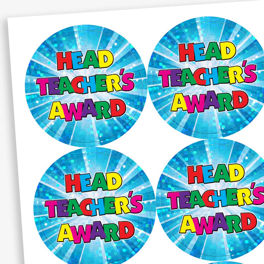 A sheet of circular 'Head Teacher’s Award' stickers with a bright blue holographic starburst background. Each sticker features bold, multicoloured text in a playful font, creating a fun and celebratory look.