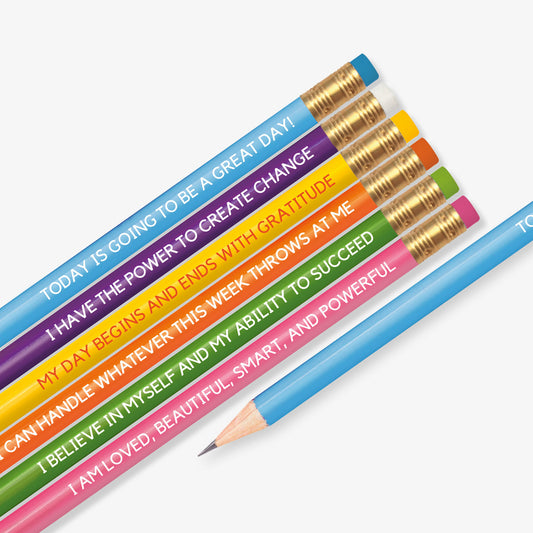 Set of six colourful pencils, each featuring a motivational affirmation. Messages include: 'TODAY IS GOING TO BE A GREAT DAY!', 'I HAVE THE POWER TO CREATE CHANGE', 'MY DAY BEGINS AND ENDS WITH GRATITUDE', 'I CAN HANDLE WHATEVER THIS WEEK THROWS AT ME', 'I BELIEVE IN MYSELF AND MY ABILITY TO SUCCEED', and 'I AM LOVED, BEAUTIFUL, SMART, AND POWERFUL'. Each pencil has a different vibrant colour with a gold ferrule and matching eraser.