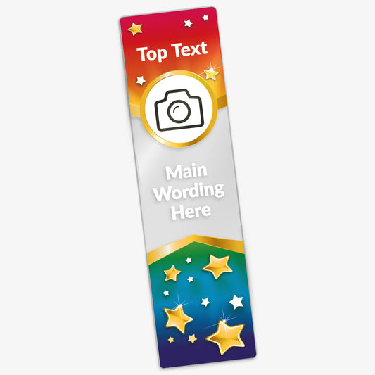 A colourful acrylic bookmark with a gradient background transitioning from red at the top to blue and green at the bottom, decorated with golden and white stars. The top features placeholder text 'Top Text' above a circular photo icon. Below that is the main area for custom text, marked 'Main Wording Here'. The overall design is vibrant and celebratory, suitable for recognition or motivational purposes.