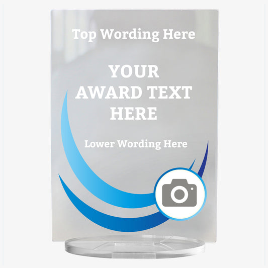 A rectangular, clear acrylic award plaque standing on a circular base. The design features curved blue wave graphics on the left side, and a camera icon in a circle at the bottom right, indicating space for a custom photo. The text areas are labelled 'Top Wording Here', 'YOUR AWARD TEXT HERE', and 'Lower Wording Here', allowing for personalisation. The overall style is sleek and modern, ideal for formal recognition.