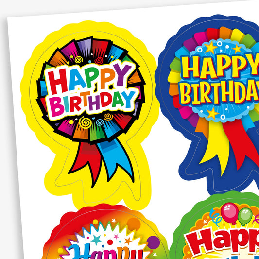 Sheet of colourful birthday stickers featuring rosette-style designs with bold 'Happy Birthday' text. Each sticker includes bright patterns and ribbon elements in various colours such as yellow, blue, red, and rainbow themes.