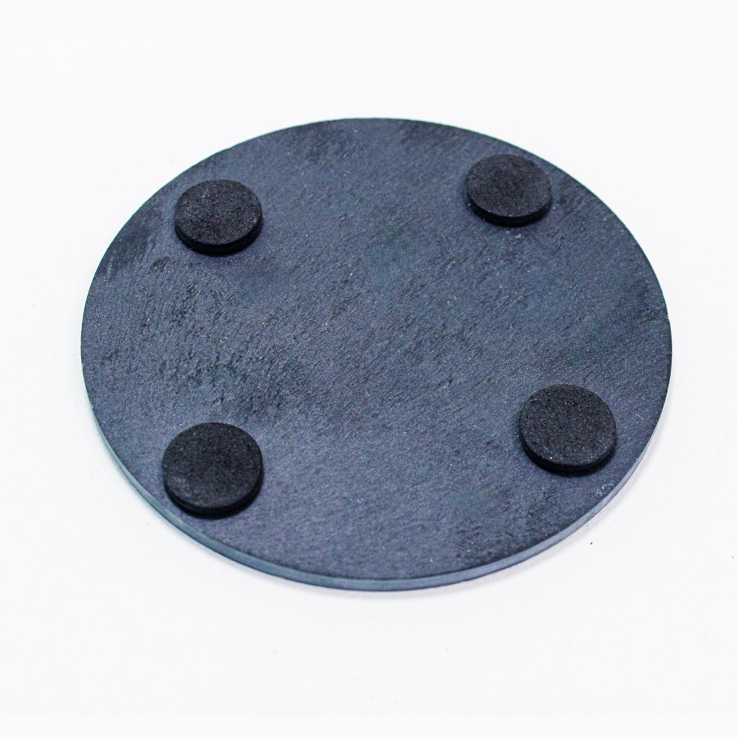 Underside of slate coaster showing four pads to avoid scratching on surfaces.