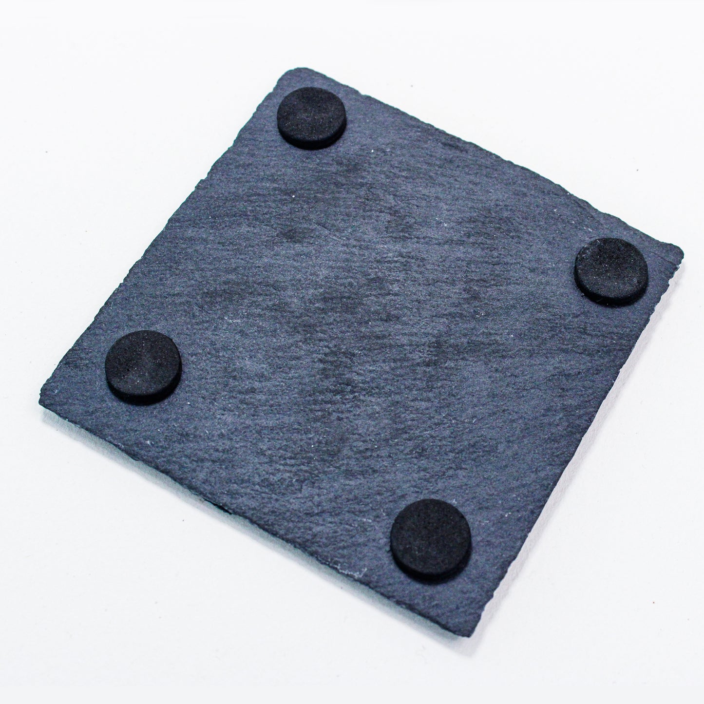 Reverse of square black slate coaster showing felt feet.