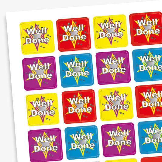 A sheet of colourful square reward stickers featuring the phrase 'Well Done' in white text with a starburst background. The stickers come in red, yellow, blue, and purple, each with a decorative star and confetti design.
