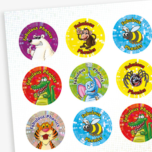A sheet of circular 'Fabulous Phonics' reward stickers with colourful holographic backgrounds and cartoon animals, including a polar bear, monkey, bee, crocodile, elephant, spider, and tiger. Each sticker features the phrase 'Fabulous Phonics' in curved text above the character.