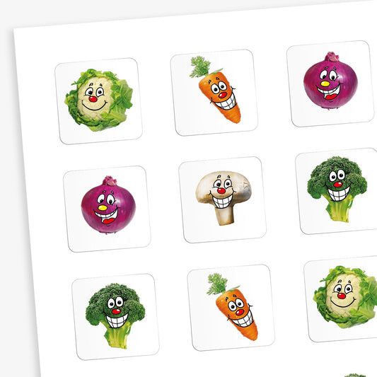 A sheet of white square stickers with a different smiling vegetable on each one including: cauliflower, carrot, mushroom and brocolli.