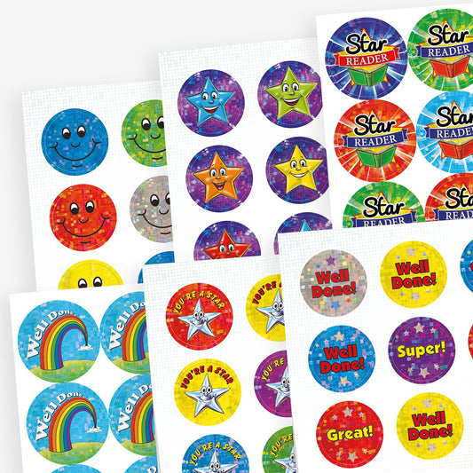 Assorted sheets of colourful, holographic reward stickers featuring positive messages such as 'Well Done', 'You're a Star', 'Star Reader', and 'Super!'. Designs include smiling faces, rainbow, stars, and vibrant colours in sizes of 20mm and 25mm.