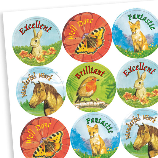 A sheet of circular reward stickers featuring realistic animal illustrations and motivational phrases. Designs include a rabbit with 'Excellent', a butterfly with 'Well Done', a fox with 'Fantastic', a horse with 'Wonderful Work', and a robin with 'Brilliant'. The backgrounds are soft and natural, giving the stickers a gentle, countryside theme.