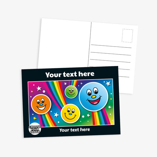 A vibrant postcard with a black border and colourful illustration on the front, featuring five smiling, cartoon-style face icons of different colours (orange, yellow, green, blue, and red) floating among stars and rainbows on a pink and purple gradient background. The top and bottom sections say 'Your text here'. A badge in the corner reads 'Choose your image'. The reverse side includes space for a message, address lines, and a stamp box.