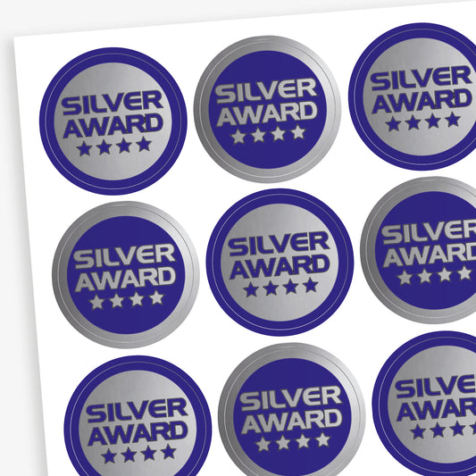 Sheet of 70, 25mm circular stickers with a metallic silver finish; each sticker features the text 'SILVER AWARD' above 4 stars.  The sheet has 50% stickers with a silver base and blue text, and 50% a blue base with silver text.