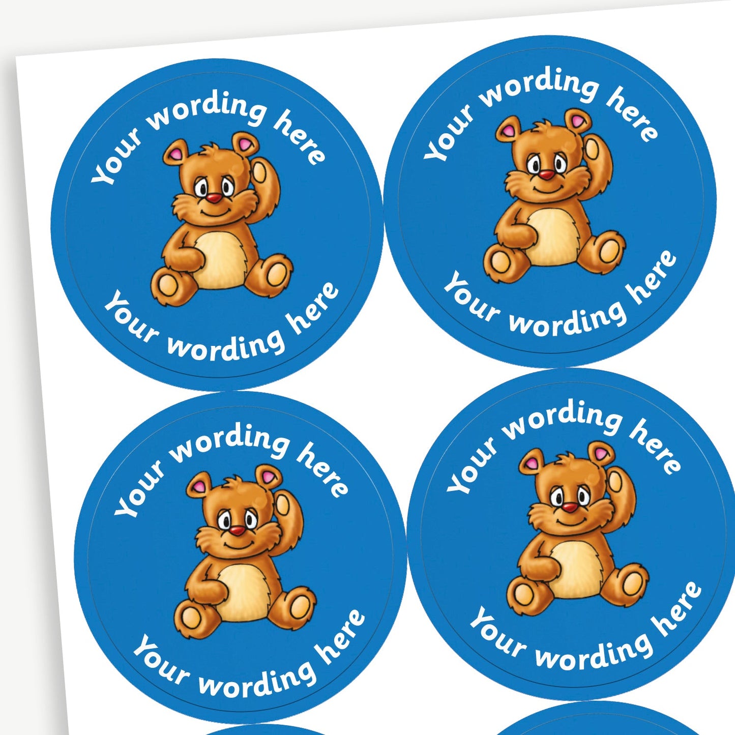A sheet of blue circular stickers featuring a teddy bear in the centre; curving above and below the image is space for personalisation 'Your wording here' in a clear, bold font.