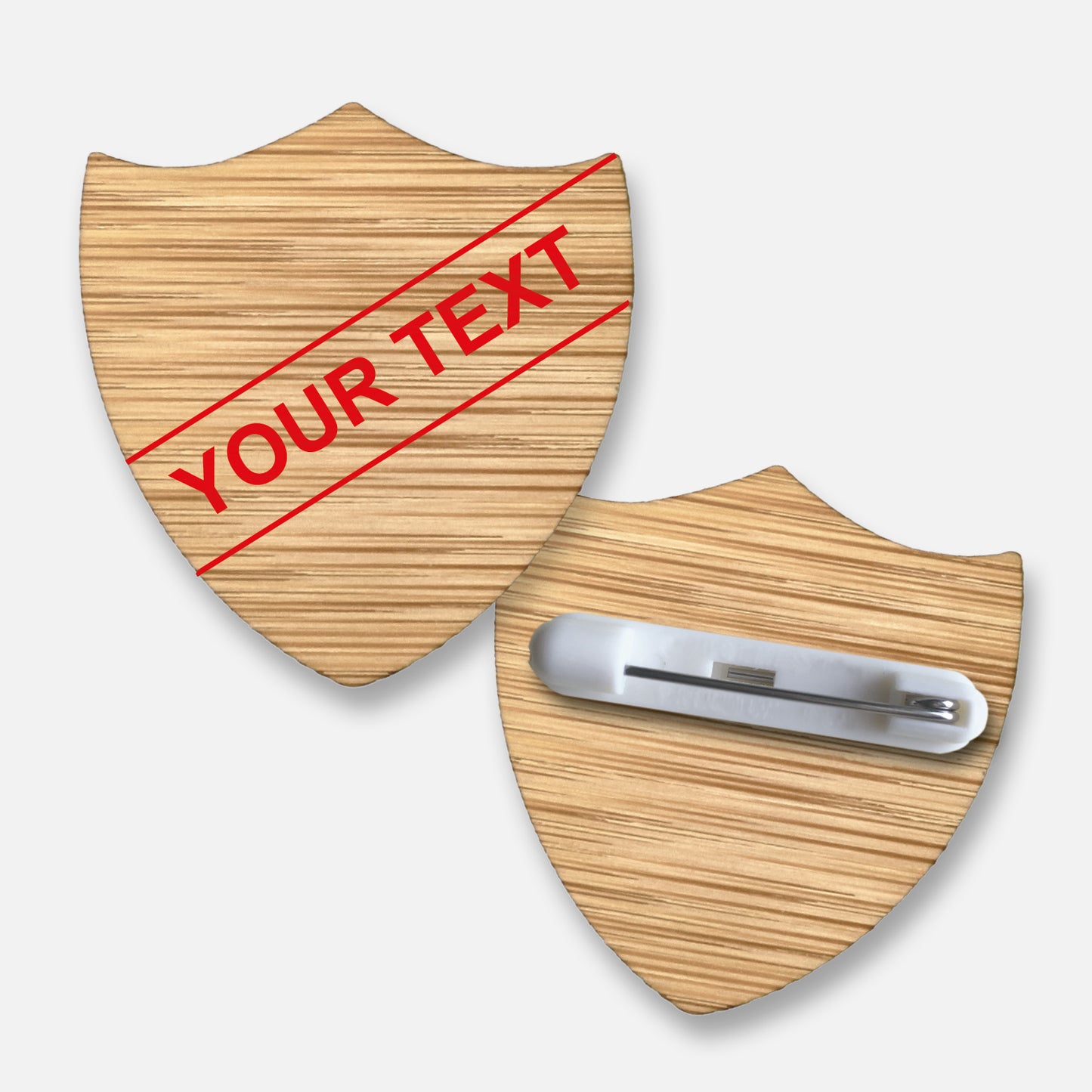 Personalised bamboo shield-shaped badge with natural wood grain finish. Features a diagonal single line of customisable text in your choice of font and colour; measures approximately 34mm x 36mm and includes a pin fastening on the reverse.