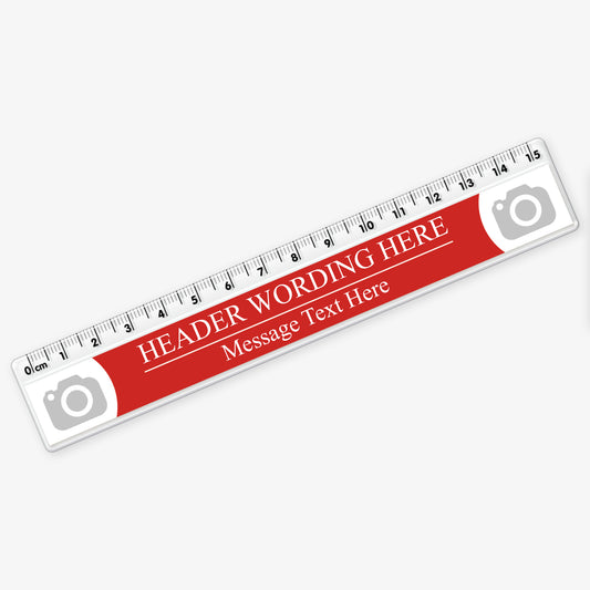 Customisable 15cm plastic ruler with a red background. Includes placeholder text 'HEADER WORDING HERE' and 'Message Text Here' in white, with camera icons at both ends indicating space for logos or images. The ruler features centimetre and millimetre markings along the top edge.