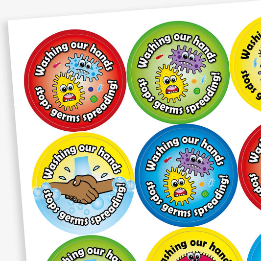 Sheet of round colourful stickers with the slogan 'Washing our hands stops germs spreading!' Each sticker features cartoon-style germs or handwashing illustrations, in red, green, yellow, and blue backgrounds.