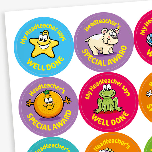 A sheet of colourful circular stickers featuring the phrases 'My Headteacher says WELL DONE' and 'Headteacher’s SPECIAL AWARD.' Each sticker displays a cheerful cartoon character, including a star, hippo, orange, and frog, with varied background colours such as blue, purple, red, and orange.