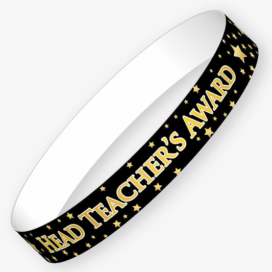 A set of ten black wristbands featuring the phrase 'HEAD TEACHER'S AWARD' in bold gold letters, surrounded by gold stars.