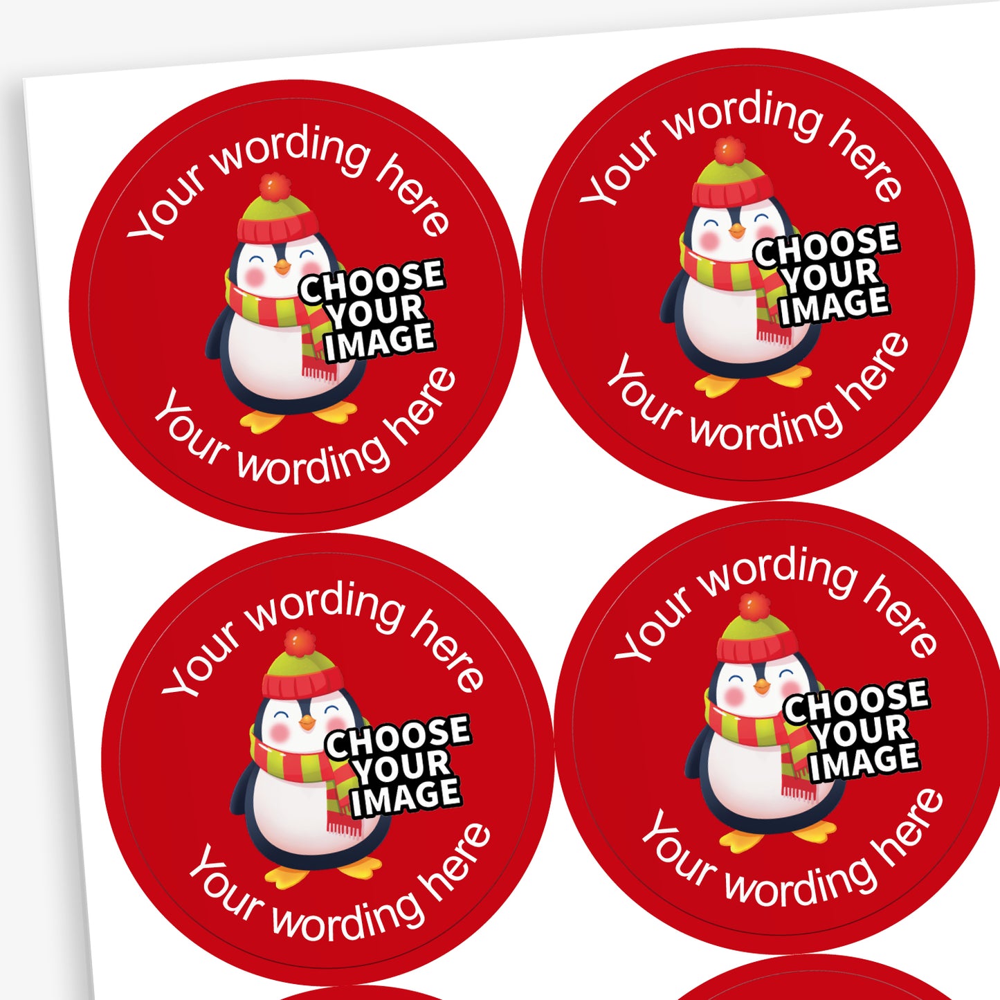 A sheet of circular red stickers featuring a festive cartoon penguin wearing a woolly hat and scarf. The stickers include placeholder text reading 'Your wording here' at the top and bottom, and 'CHOOSE YOUR IMAGE' across the penguin, indicating customisable design options.