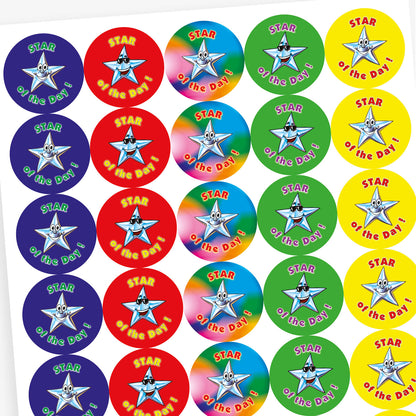 Sheet of round 'Star of the Day' reward stickers featuring smiling cartoon stars with expressive faces. Each sticker has the same message but comes in a variety of vibrant background colours, including green, blue, red, and yellow.