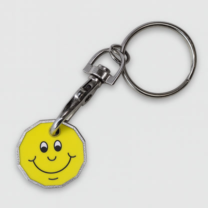 Trolley coin keyring with a smiley face design on a yellow background