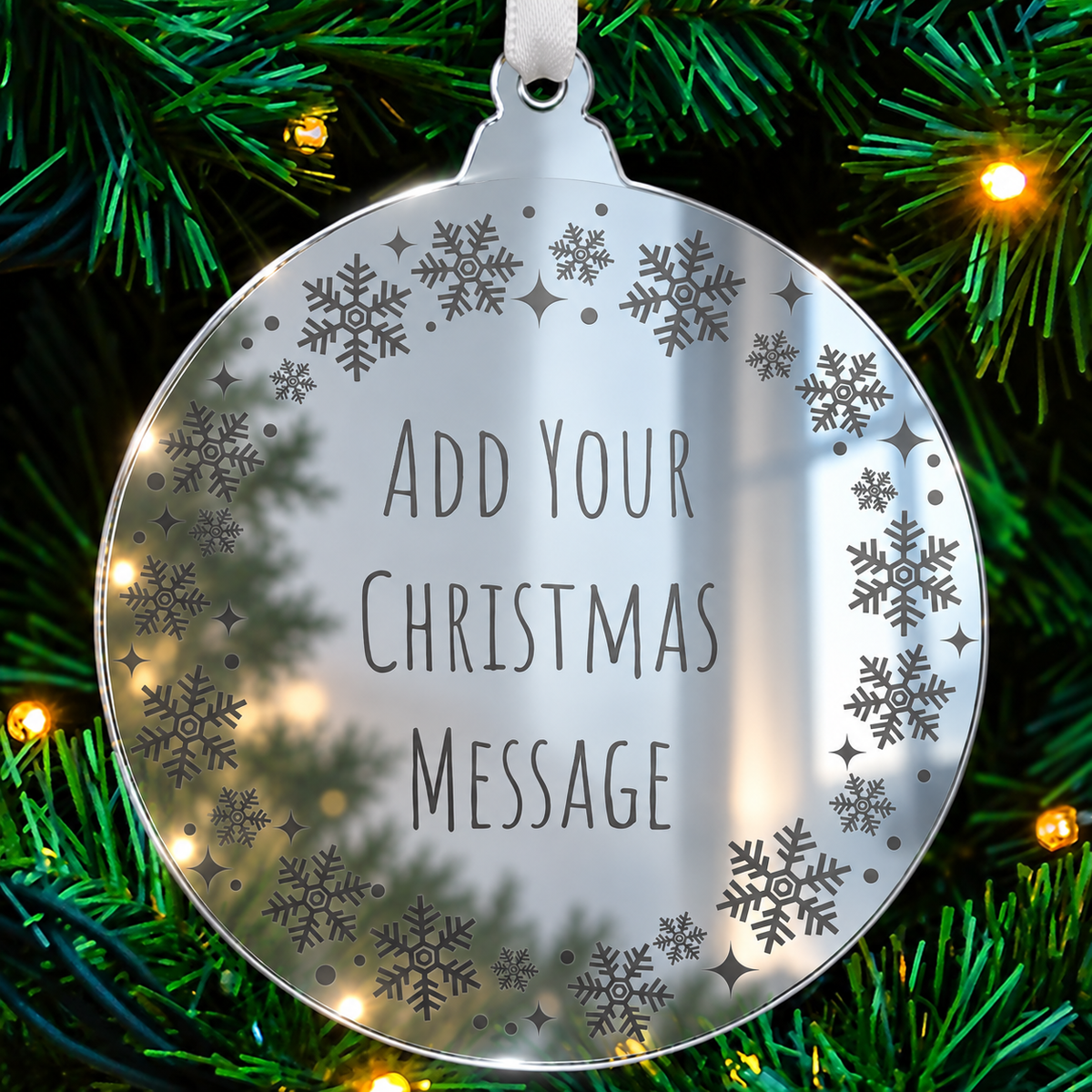 Personalised mirrored acrylic Christmas bauble with etched festive border hanging on a Christmas tree