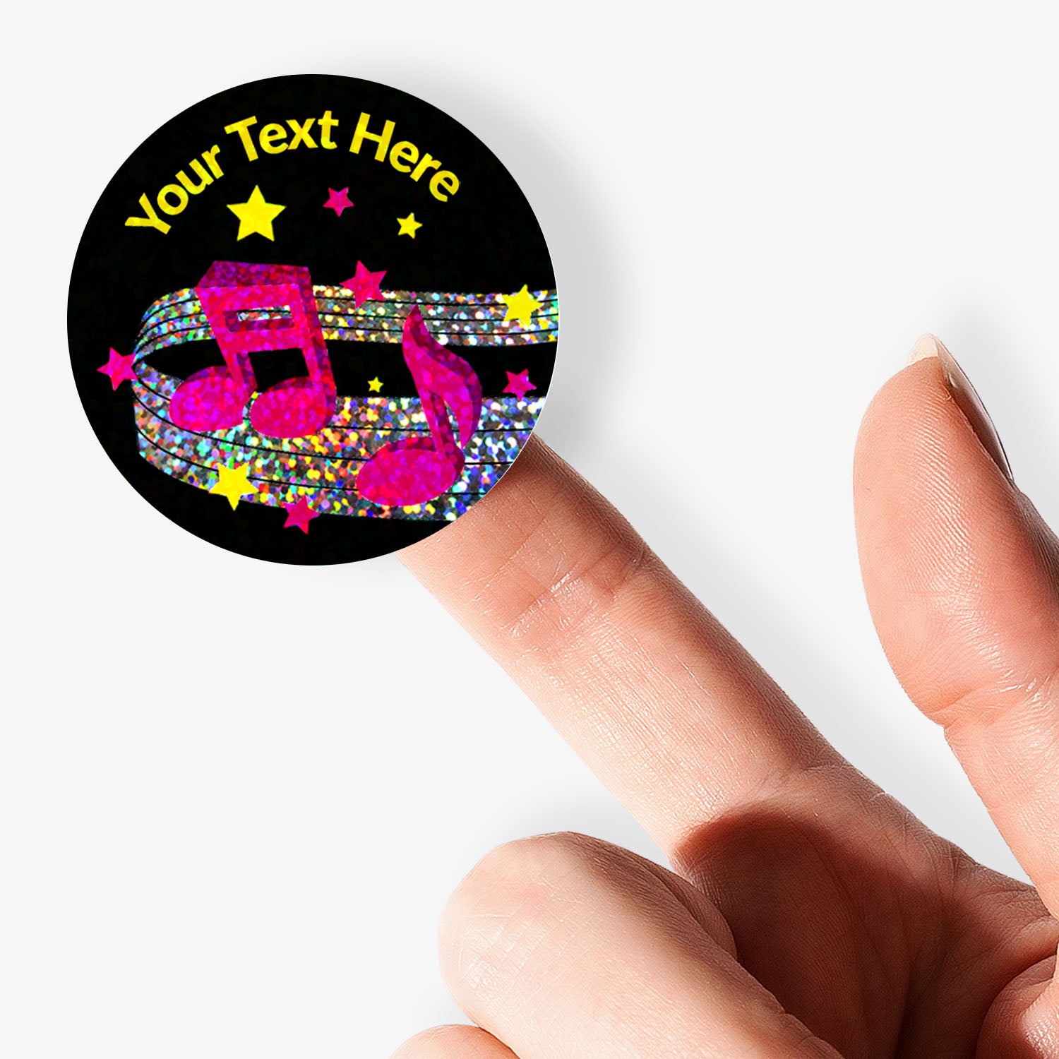 Personalizable button badge with music notes and stars design, held by a hand.