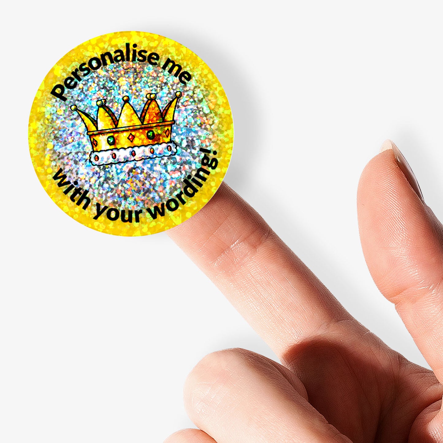 Round customizable sticker with a crown design and text on a yellow background, held by a hand.