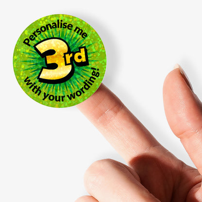 Green sticker with 'Personalise me 3rd' text held by a finger on a white background
