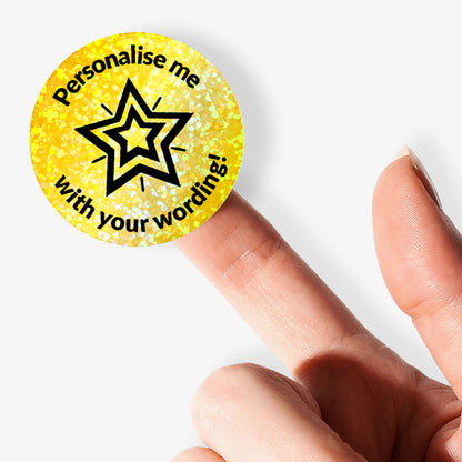 Round gold sticker with star design and text 'Personalise me with your wording!' held between fingers.