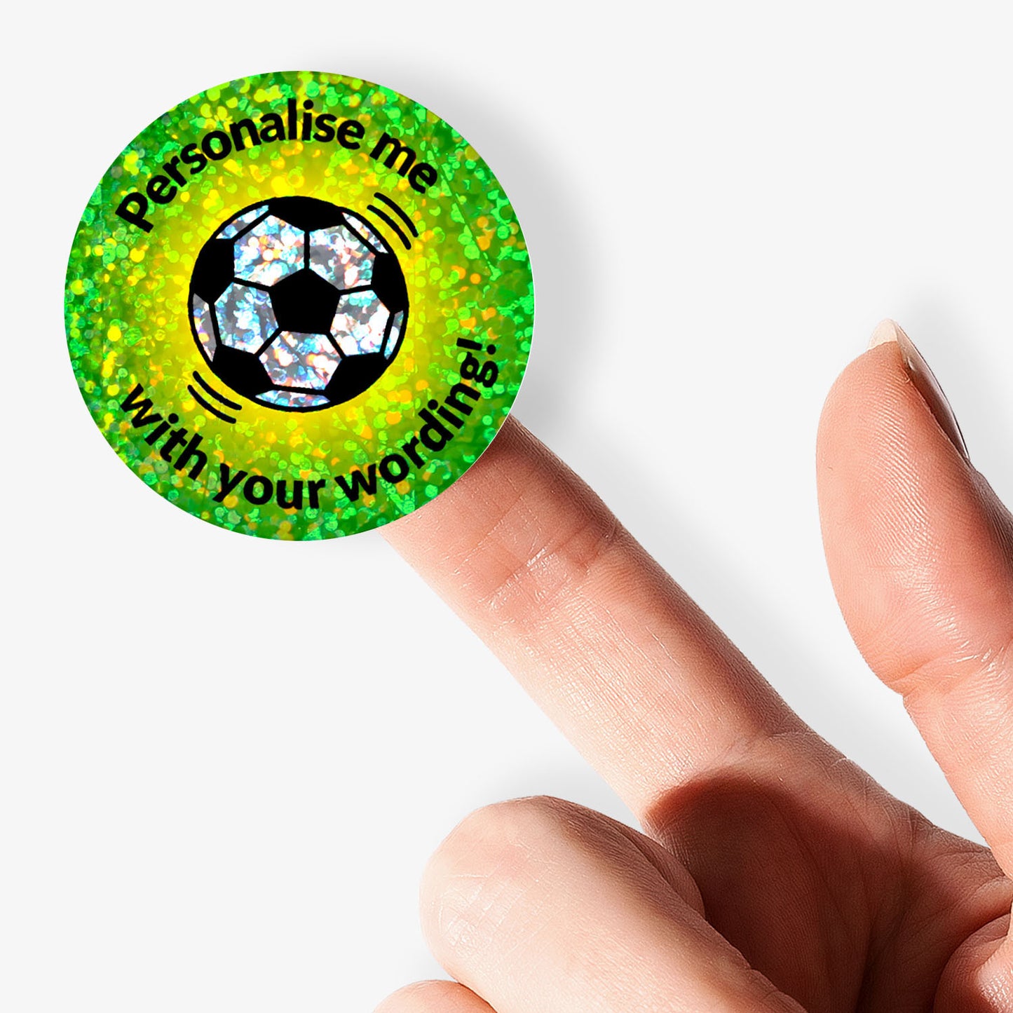 Personalised holographic round green stickers with soccer ball design and text 'Personalise me with your wording!' held by a finger.