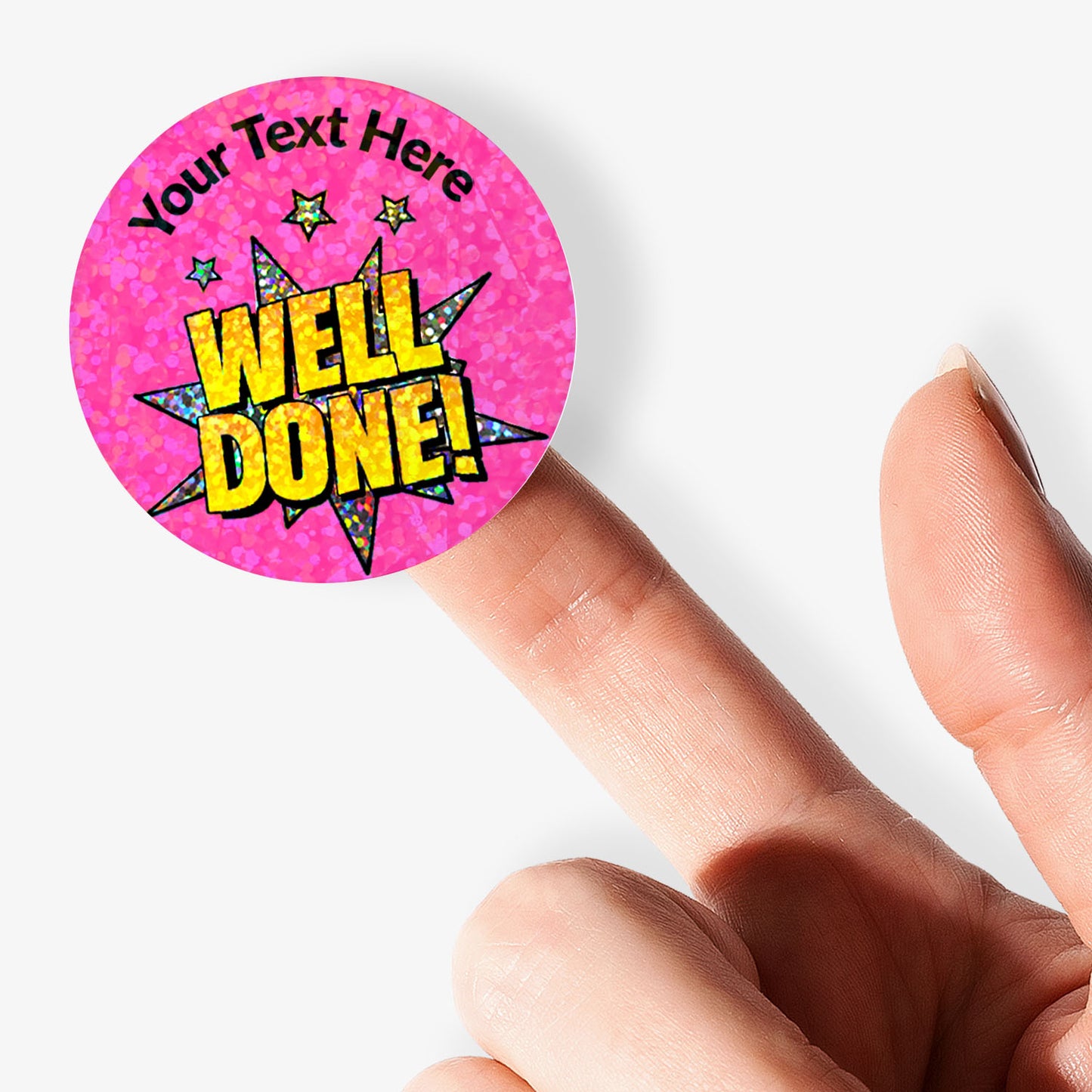 Pink 'Well Done!' sticker with customisable text held by a finger on a white background