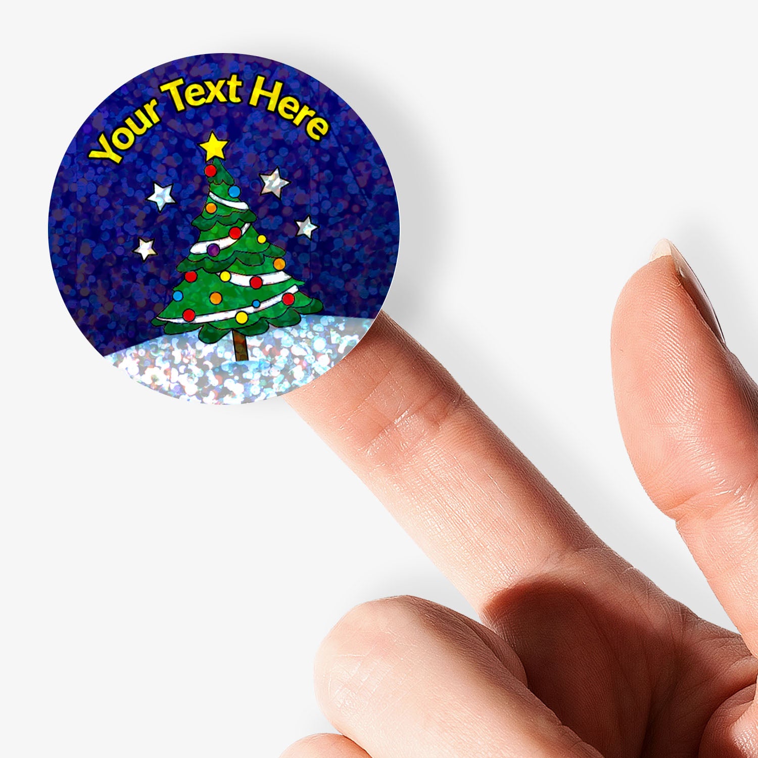Personalisable sticker with Christmas tree design held by a finger on a white background