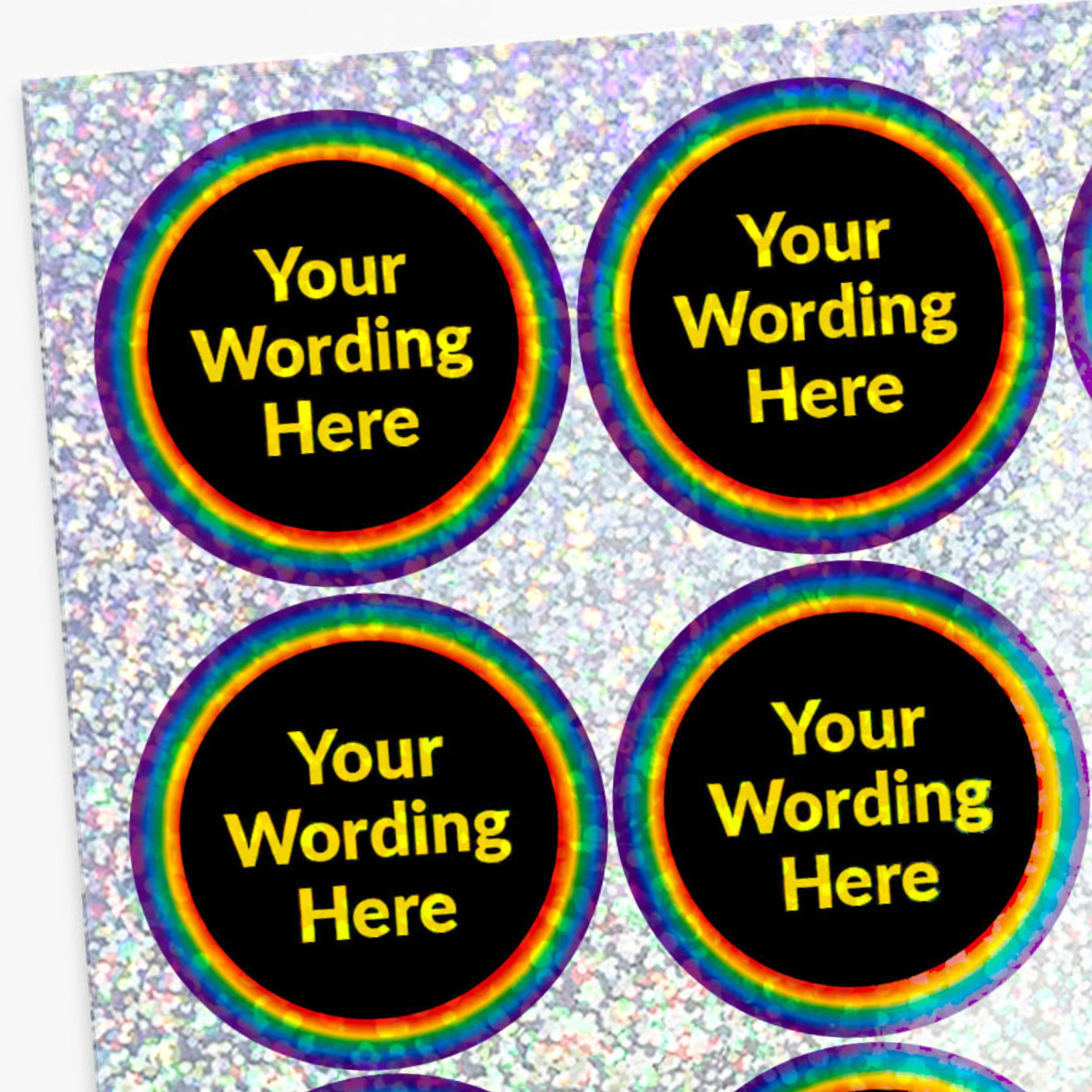 Four round stickers with rainbow borders and yellow text on a glittery background