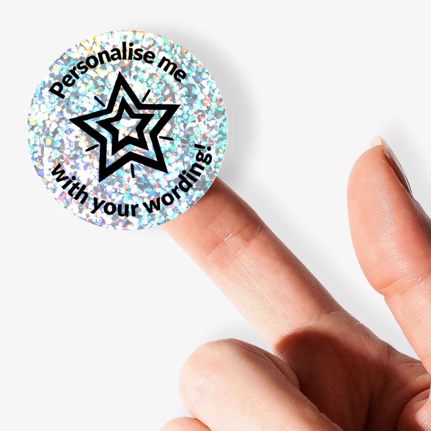 Round customisable holographic Silver sticker with star design and text 'Personalise me with your wording!' held by a finger.