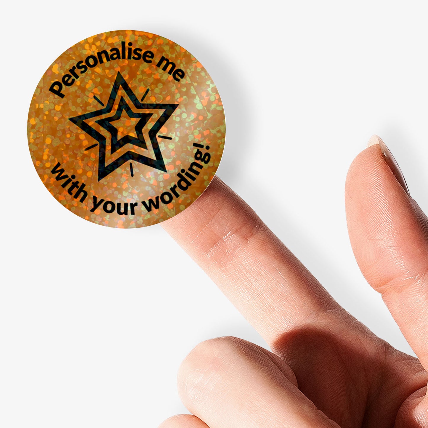 Round gold sticker with star design and text 'Personalise me with your wording!' held between fingers.