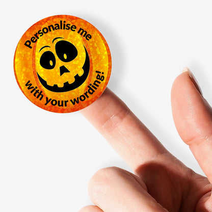 Circular sticker with sparkly pumpkin design and personalised text held by a hand.