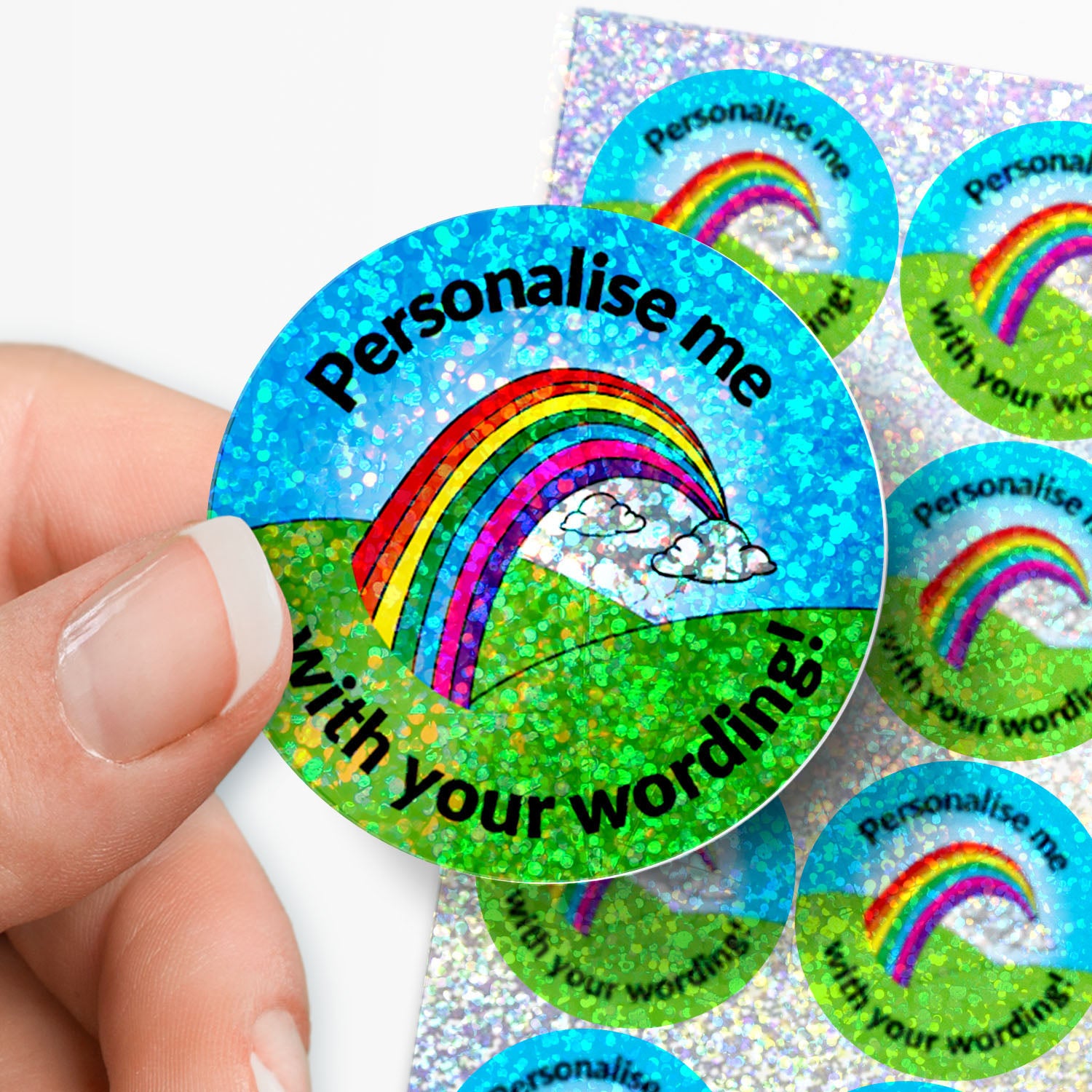 Round holographic rainbow sticker with 'Personalise me' text held by a hand.