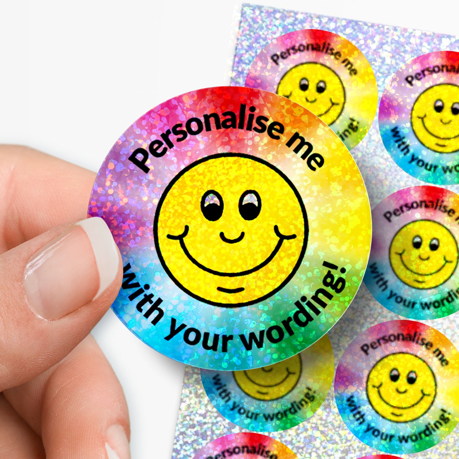Sparkly Smiley face sticker with 'Personalise me with your wording!' text held by a hand with sticker sheet in the background.