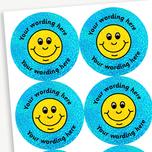 Sheet of round, holographic cyan stickers, each featuring a smiling face emoji at the centre. Surrounding is placeholder text reading 'Your wording here' above and below, indicating customisable areas for personalised messages