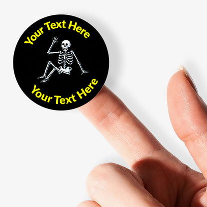 Round sticker with skeleton design and customizable text held by a finger on a white background