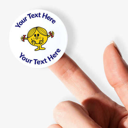 Personalisable sticker with cartoon character and text space held between fingers on a white background.