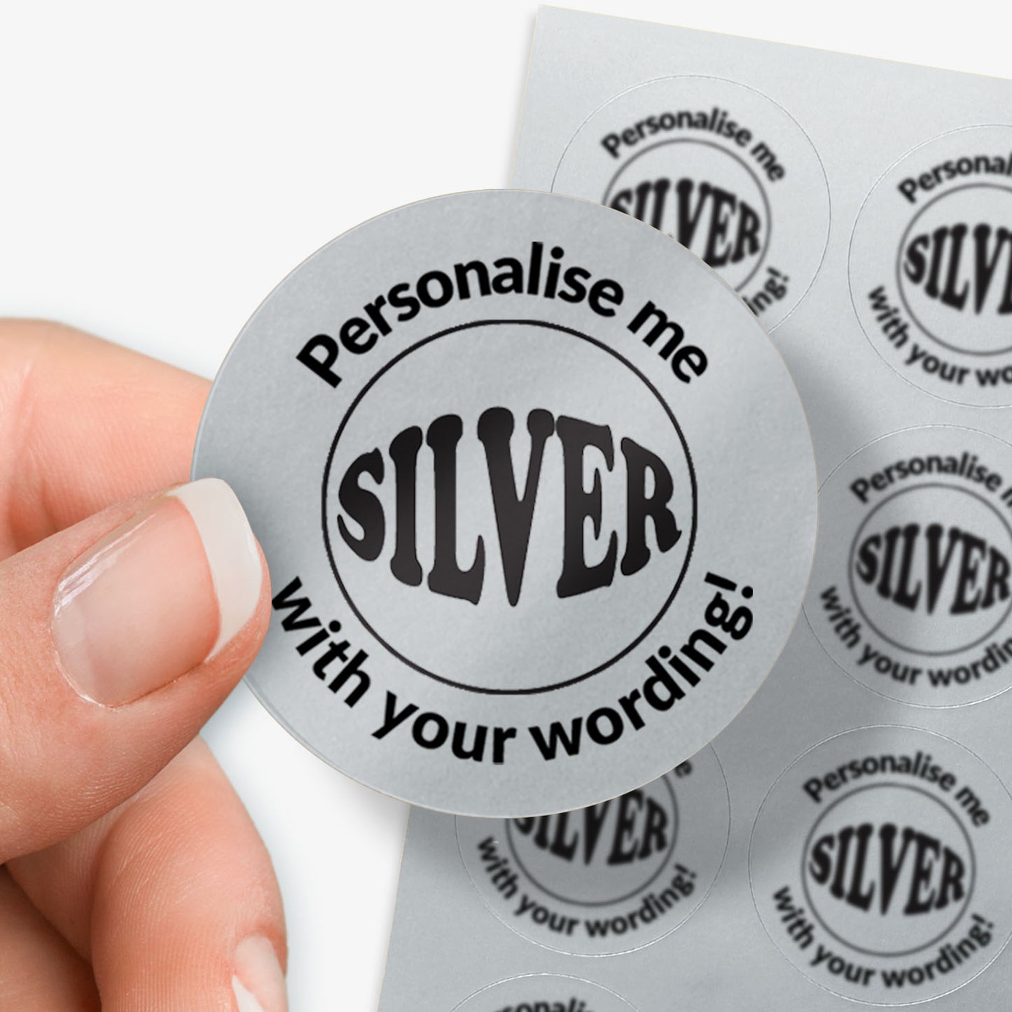Personalised round silver sticker with 'Personalise me with your wording!' text held by a hand.