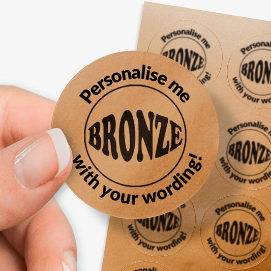 Personalised bronze circular stickers with 'Personalise me with your wording!' text, held by a hand.