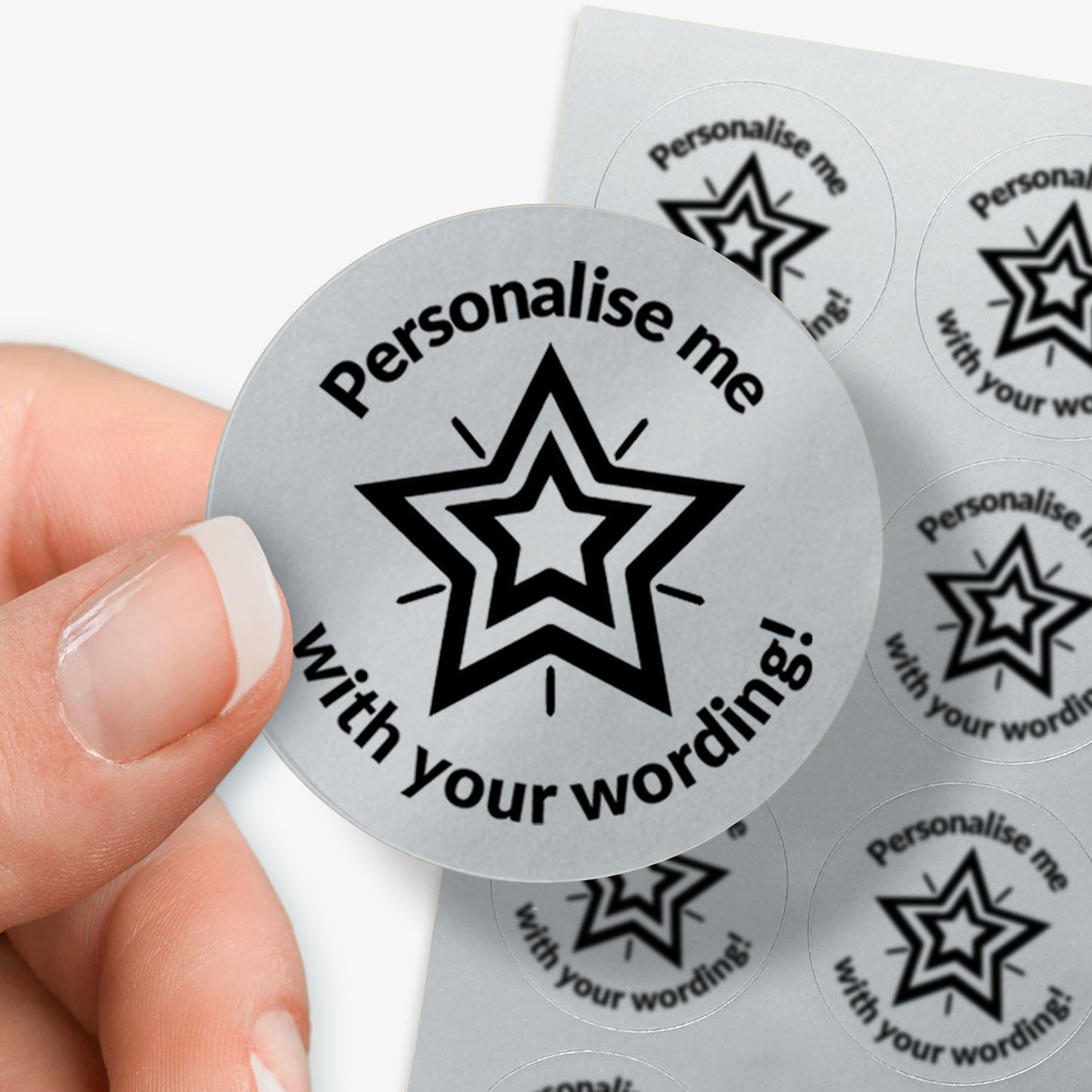 Personalised round silver sticker with star design and text 'Personalise me with your wording!' held by a hand.