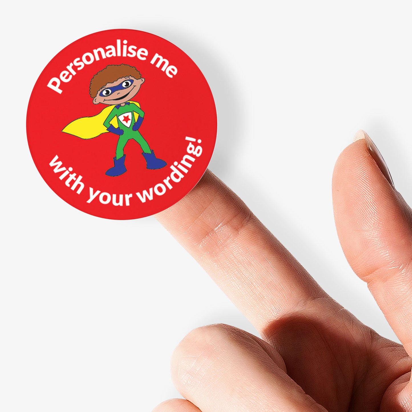 Superhero-themed personalized sticker held by a finger on a white background