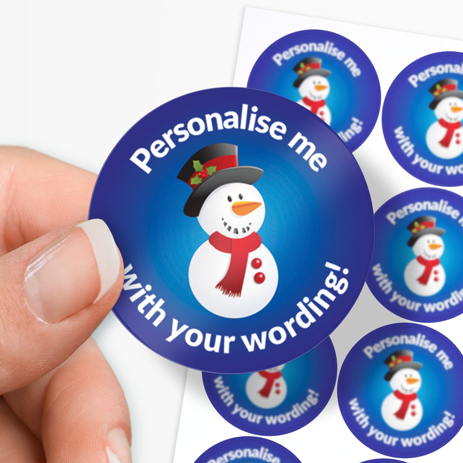 Round blue sticker with a snowman graphic and text 'Personalise me with your wording!' held by a hand.