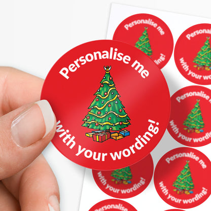 Red sticker with Christmas tree design and text 'Personalise me with your wording!' held by a hand.