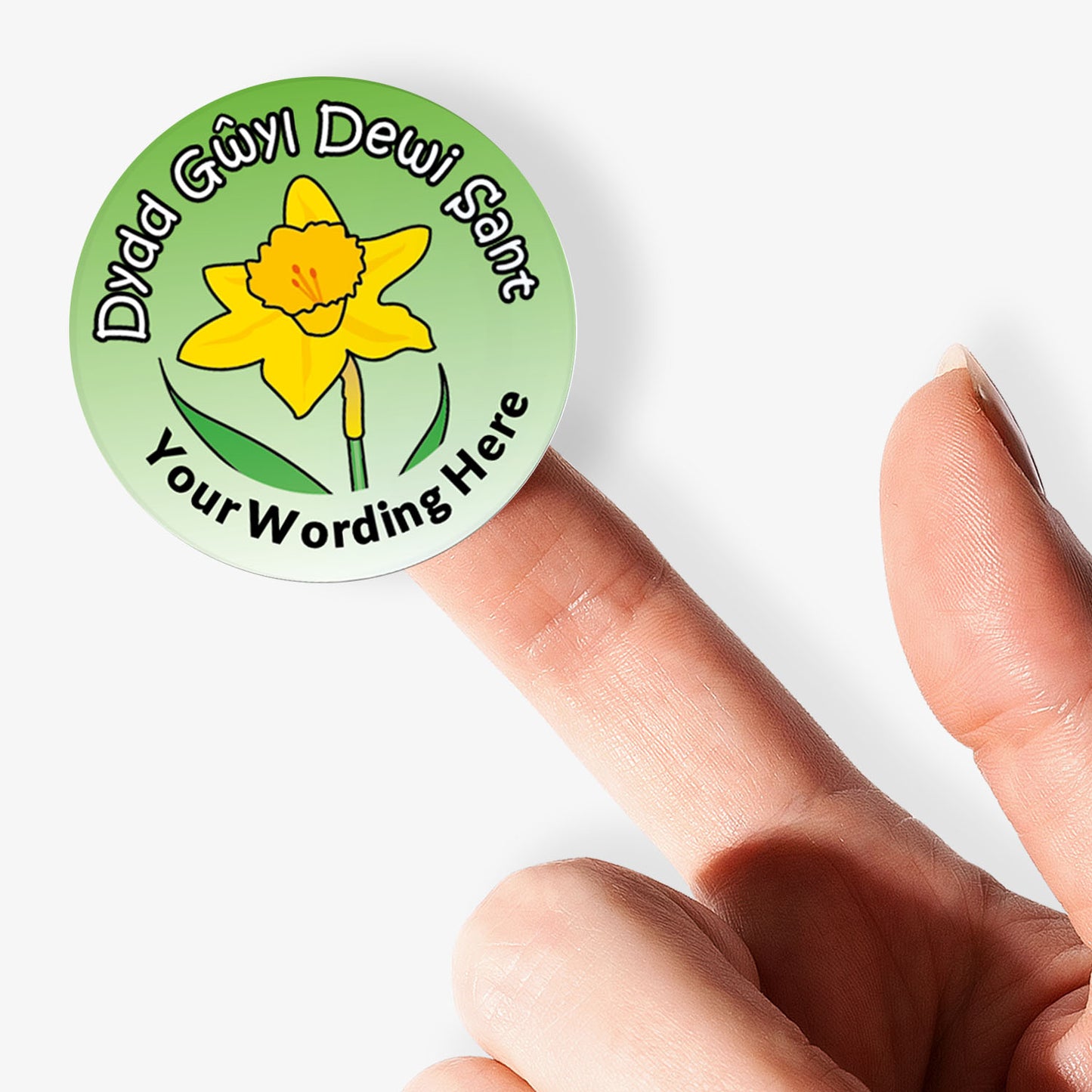 Round green sticker with a yellow flower and text held between fingers on a white background