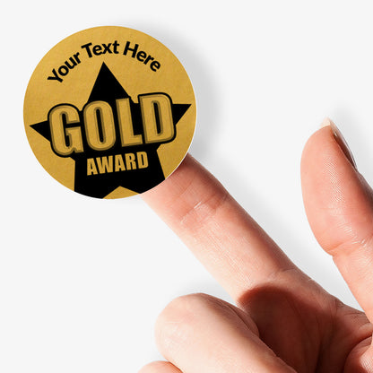Gold award sticker with customizable text held by a hand on a white background