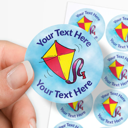 Personalizable stickers with a kite design and 'Your Text Here' text, held by a hand.
